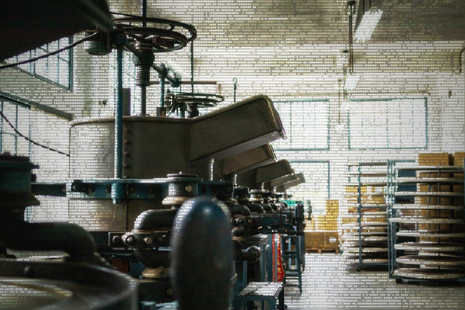 ASCII-style image of industrial production equipment on a factory floor with racks of finished goods